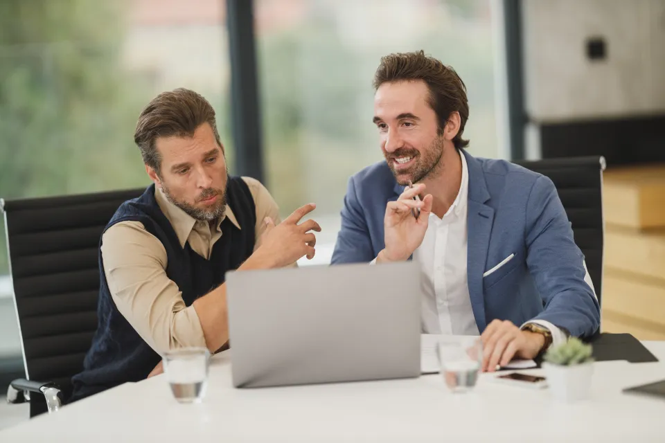 Colleagues discussing a project at a laptop